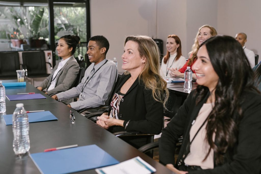 A diverse group attending a seminar in a professional setting, focused and engaged.