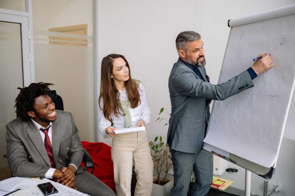 Diverse group of business professionals engaging in an office presentation, fostering teamwork and collaboration.